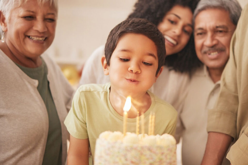 Child blowing out candles on his birthday cake