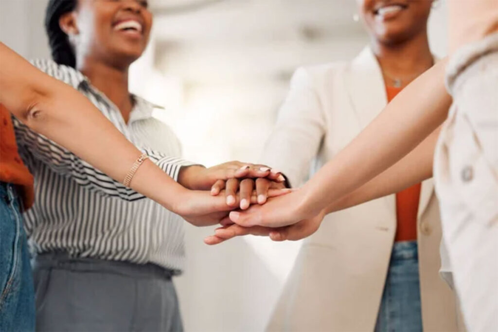 Women in a circle with hands stacked